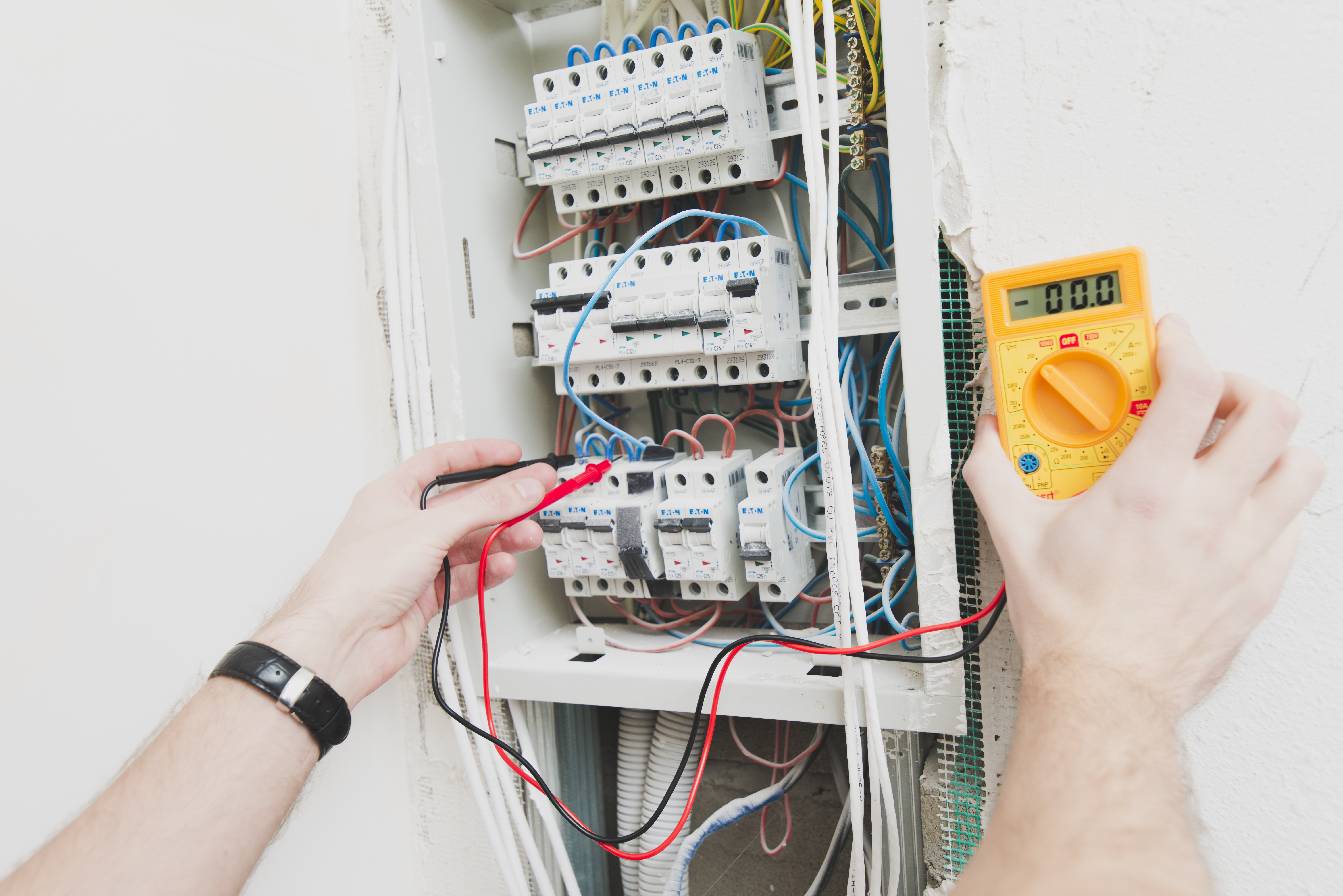 Électricien d'Okla Électrique mesurant une installation