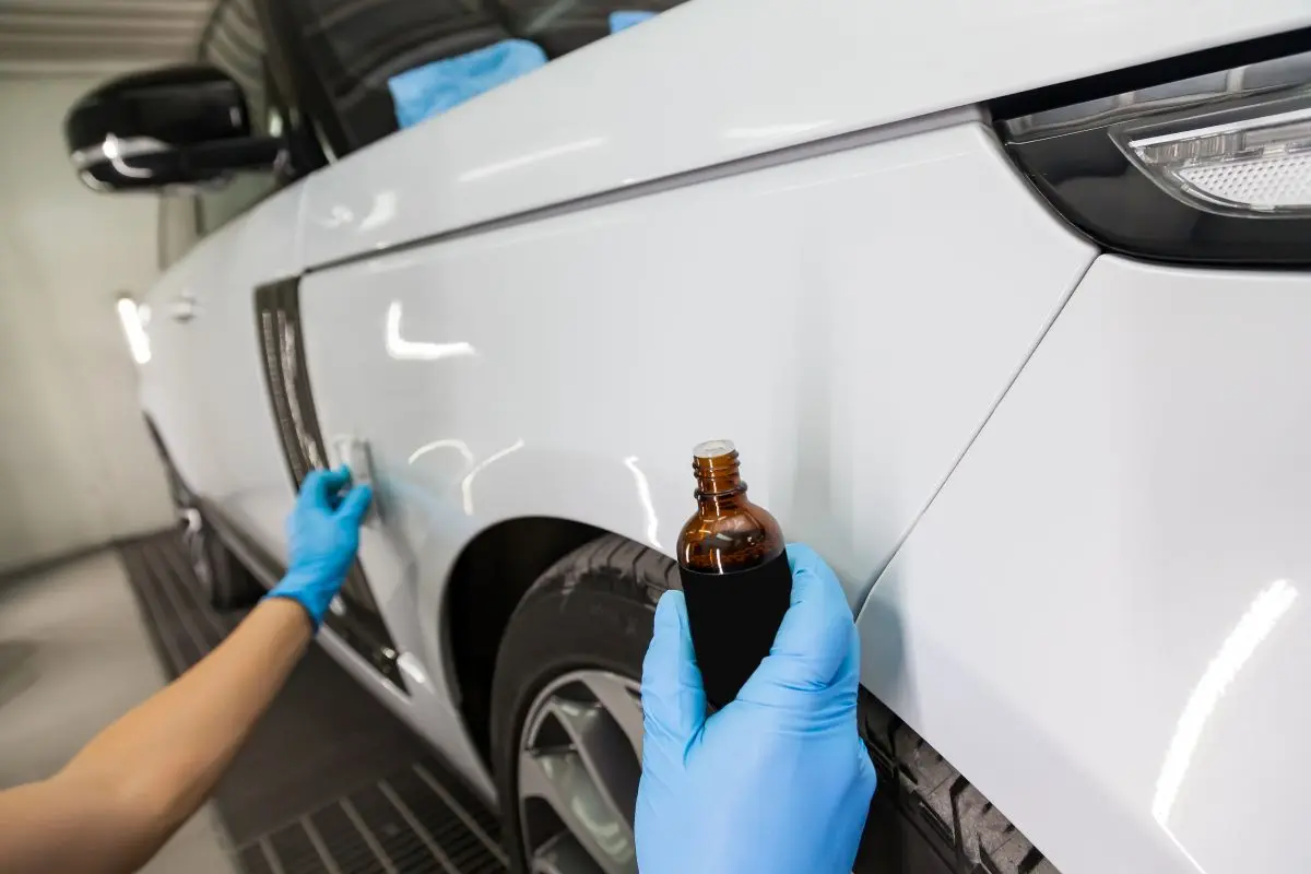 Ceramic coating being applied to a white car’s fender