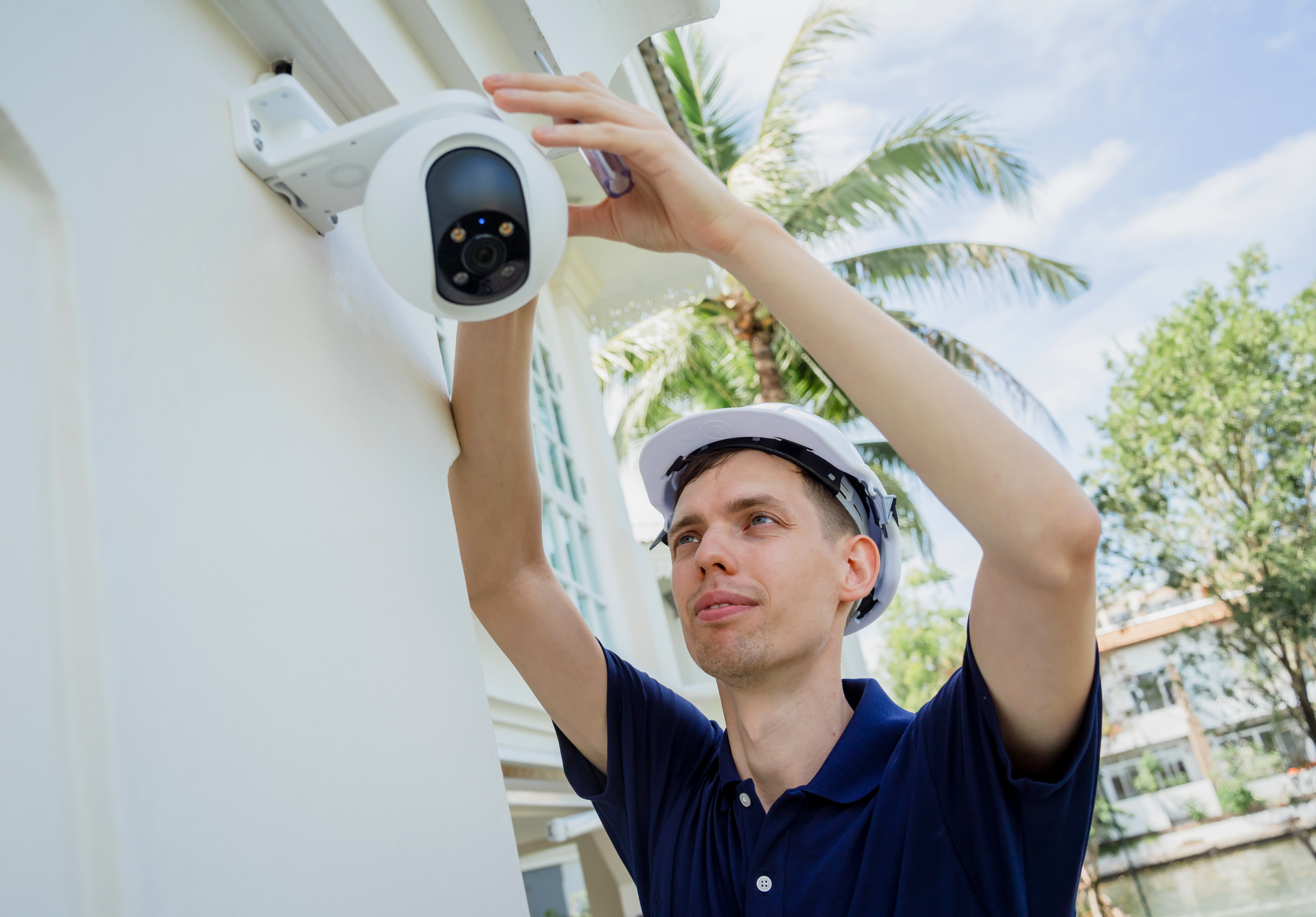 Technicien d'Okla Électrique installant une caméra de surveillance