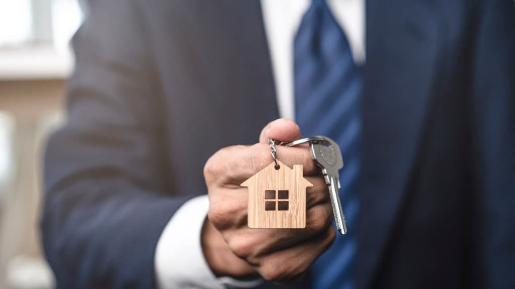 Keys with a house fob being handed over