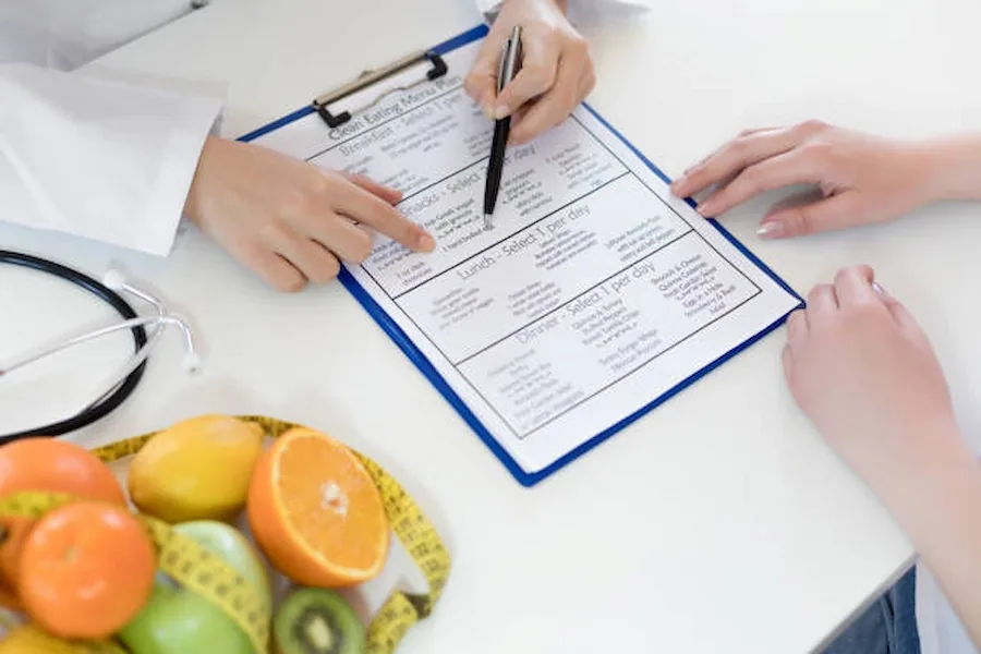 A nutrition consultation with a meal plan, fruit and measuring tape