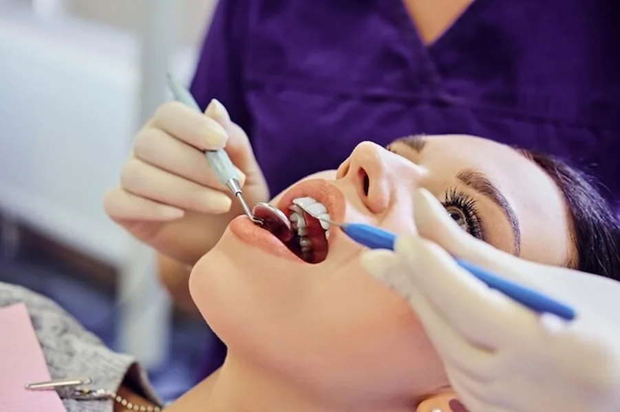 A dental examination using a mirror and handheld instrument